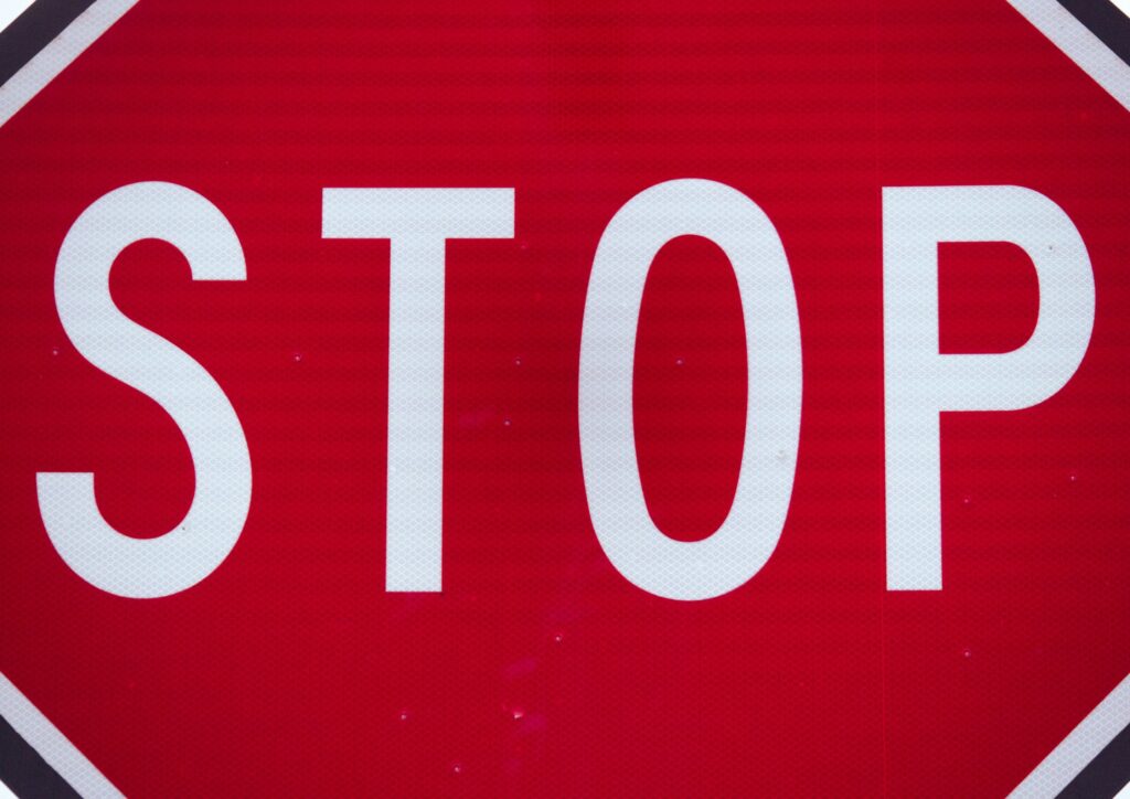 Close-up of a red stop sign with the white word STOP visible in the frame.