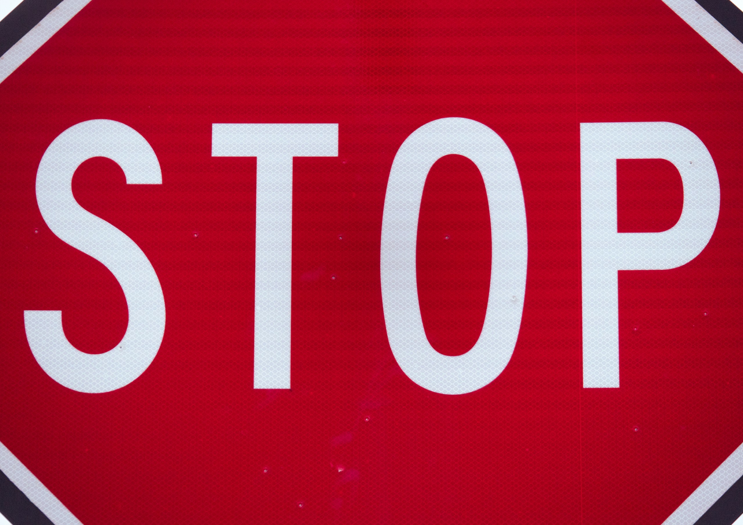 Close-up of a red stop sign with the white word STOP visible in the frame.