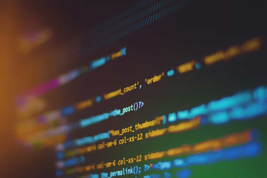 Blurred screen showing colorful programming code on a dark background.