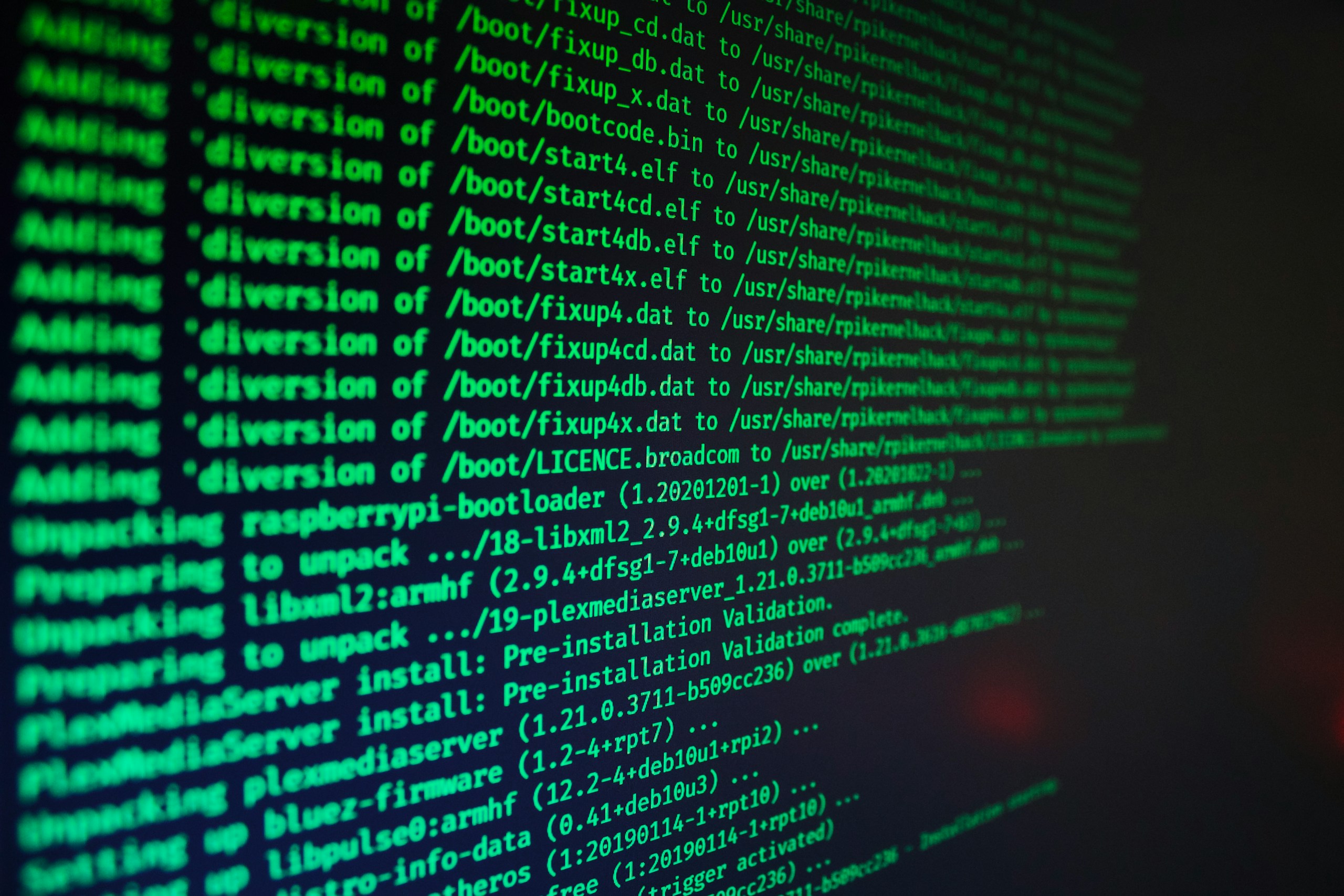 Close-up of a dark screen with bright green code lines, resembling a terminal or console output.