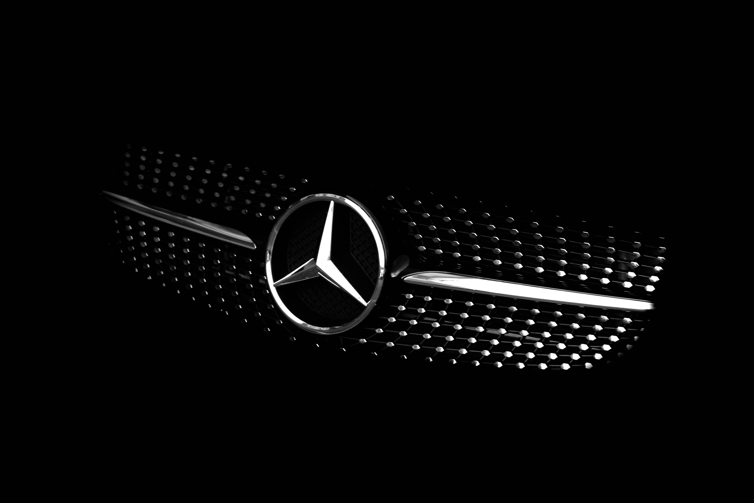 Close-up of a Mercedes-Benz front grille with the silver star emblem on a black background.