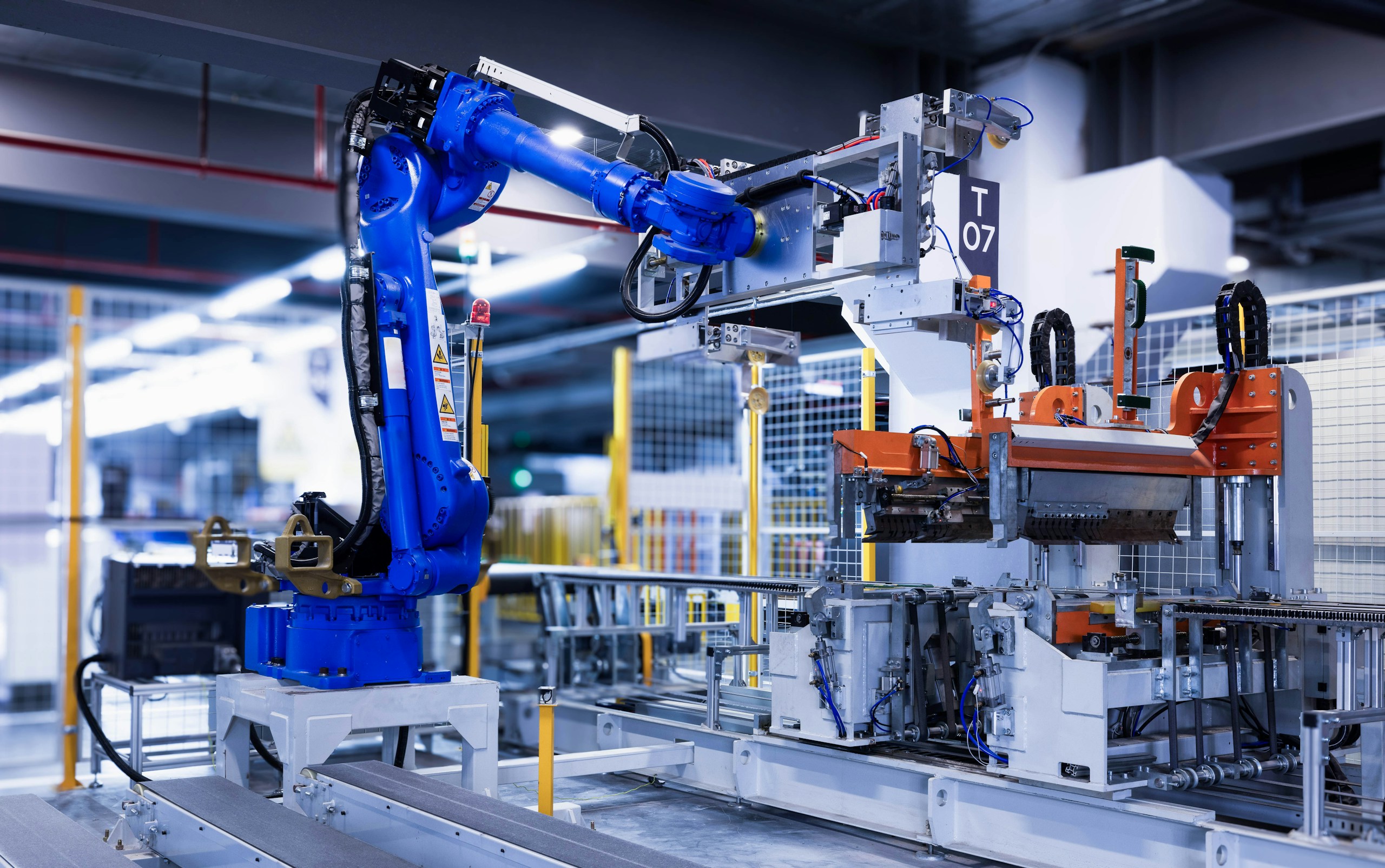 Close-up of the blue robot arm transporting a molded refrigeratorexterior laminate.
