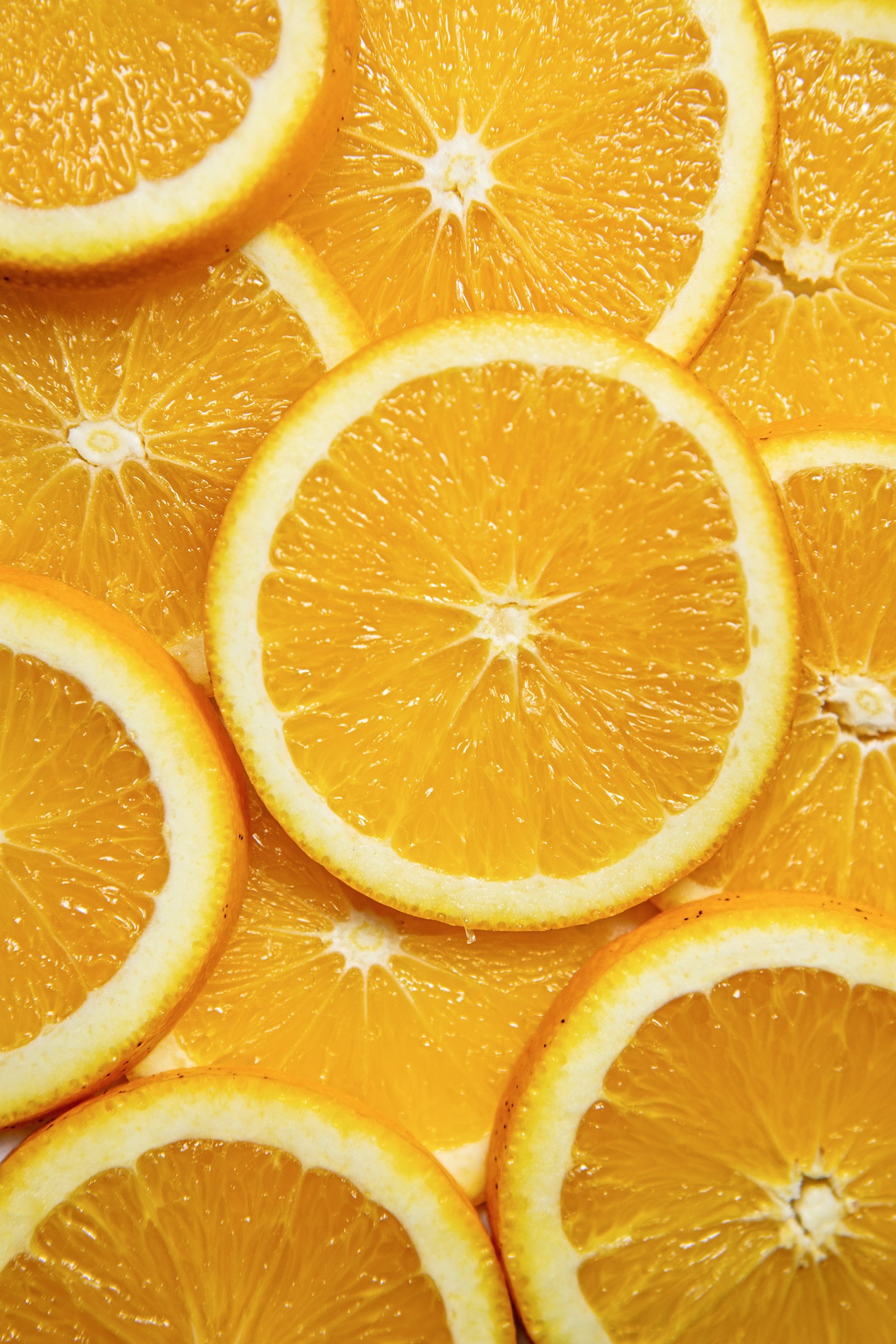 Close-up of overlapping orange slices, showing juicy segmented flesh and bright orange color.