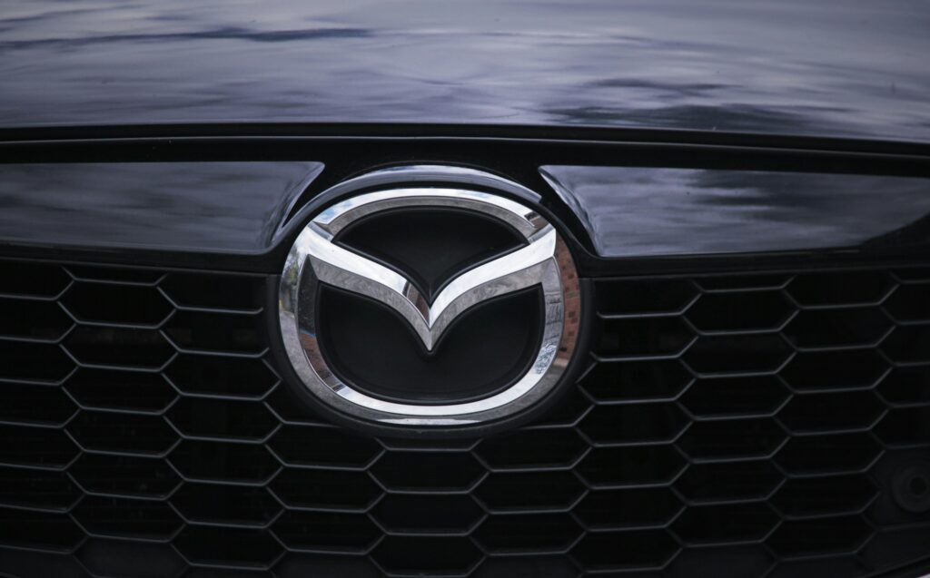 Close-up of a car's front grille featuring a silver Mazda emblem.