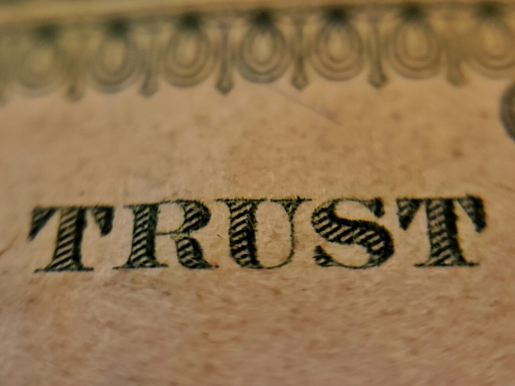 Close-up of decorative border on aged paper with a line of large black serif text at the bottom.