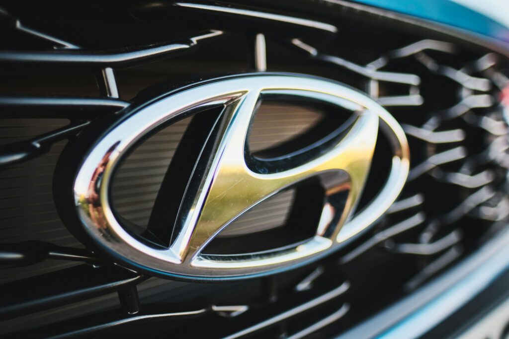 Close-up of a chrome Hyundai emblem on a black car grille