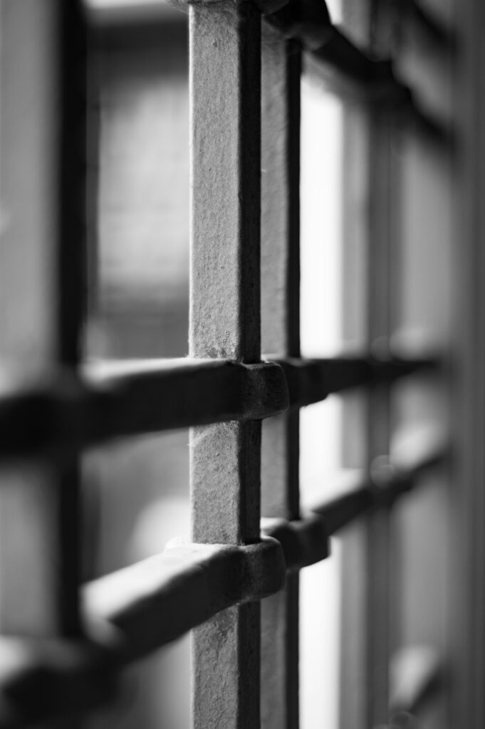 Close-up of rusted metal railing balusters with a shallow depth of field in black and white.