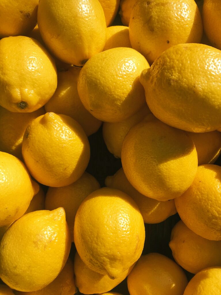 Close-up of a pile of bright yellow lemons with textured peels.